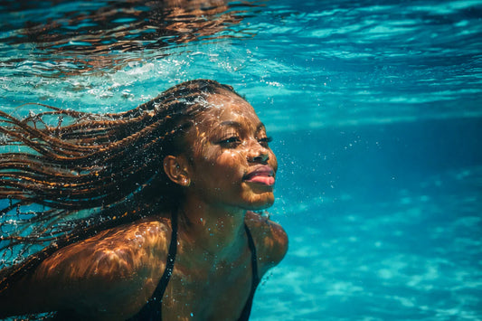 woman in water with non-toxic braids flowing