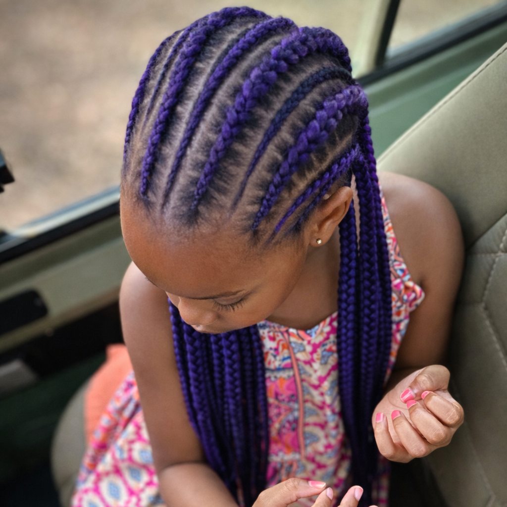 Child with purple non-toxic braided hair sitting inside a safari vehicle